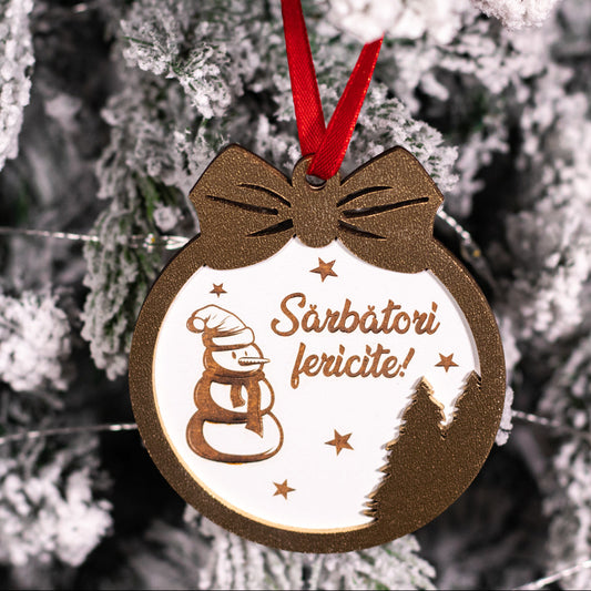 Globuleț de Crăciun din lemn cu mesaj „Sărbători Fericite”, agățat într-un brad împodobit.